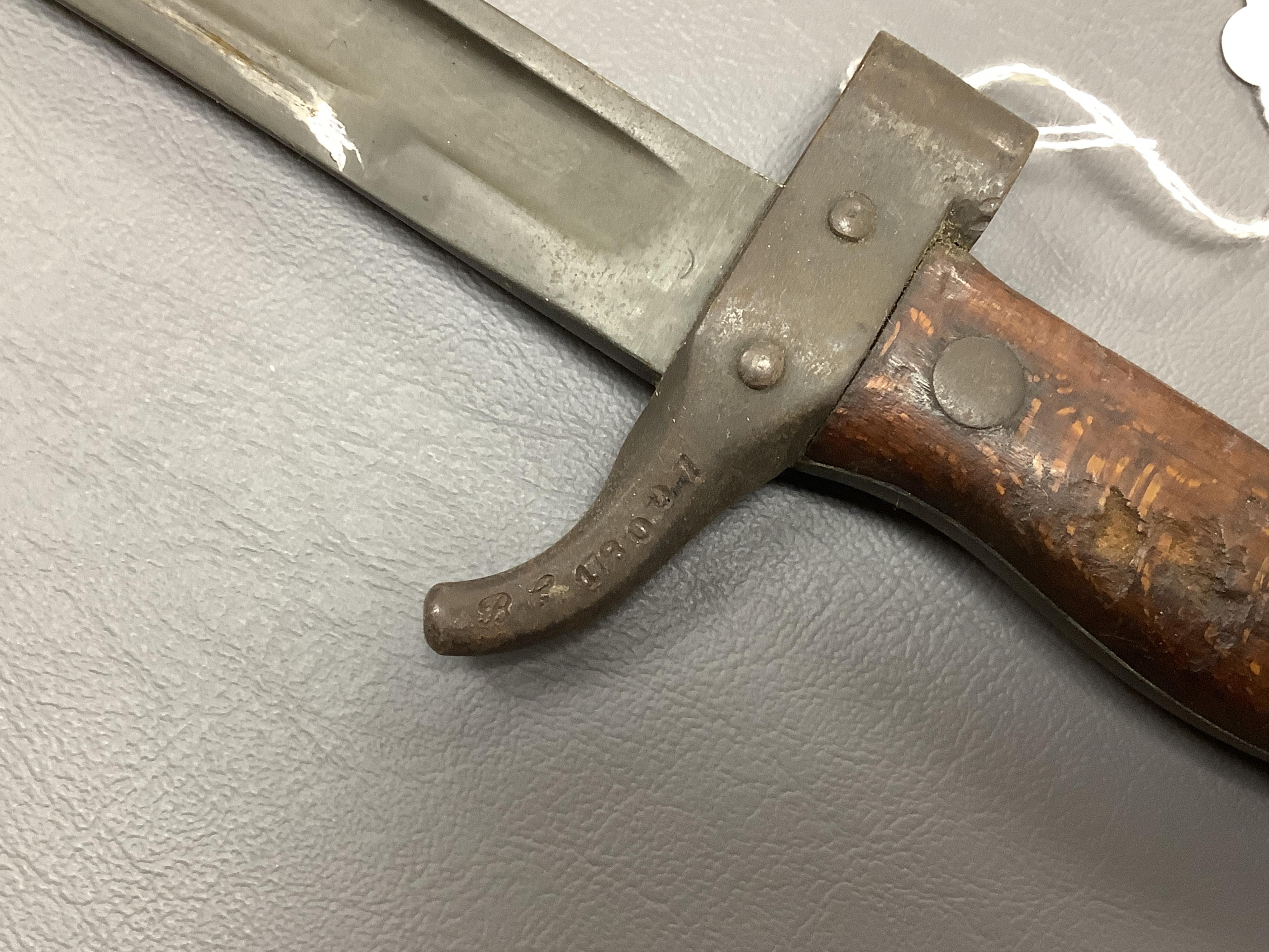 A First World War Turkish army officer’s sword, with pipe back blade, regulation iron guard pierced with crescent and moon, chequered horn grips, in its iron scabbard, together with an unidentified bayonet in its scabbar